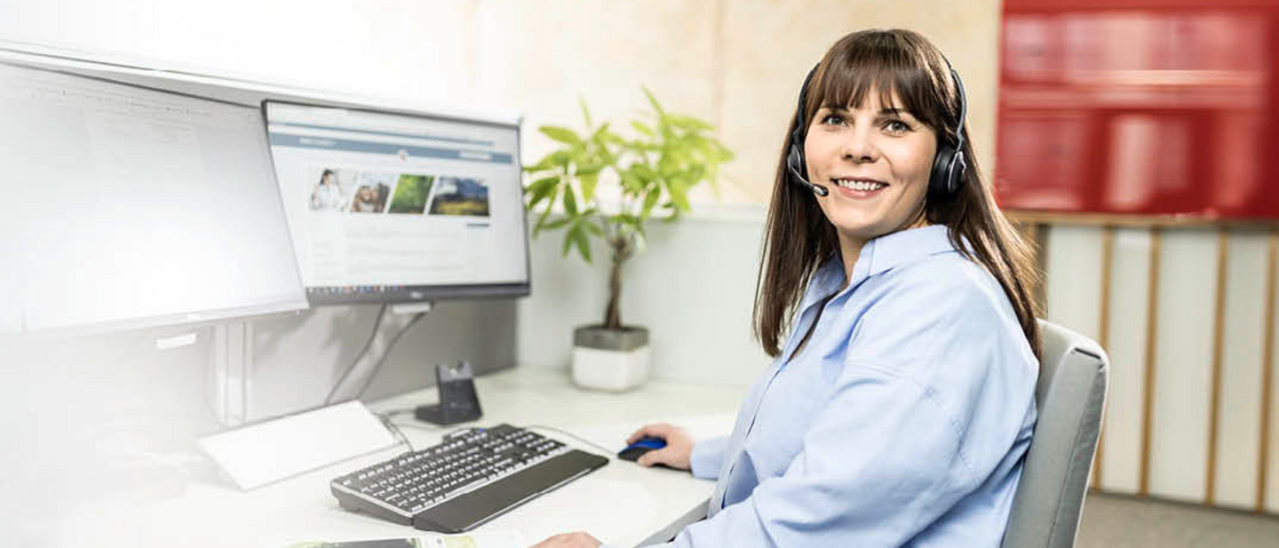 A PARI service employee sits in front of a computer with a headset and advises a customer over the phone