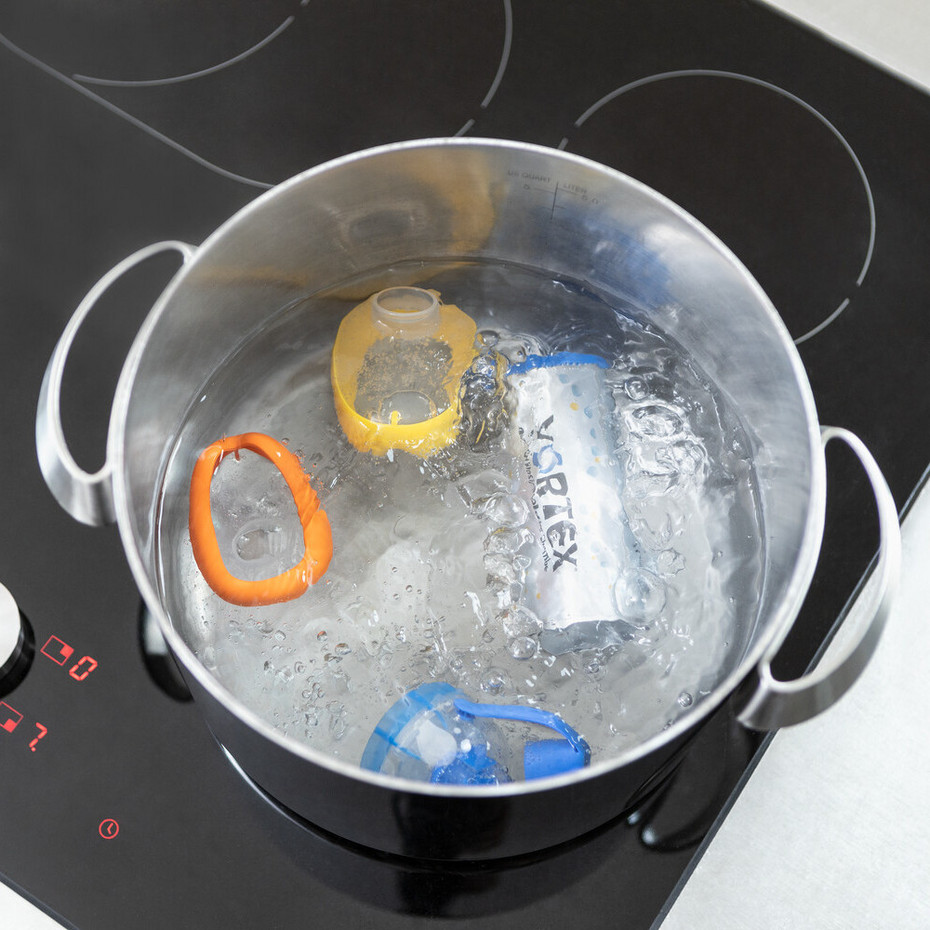 Reinigung der Inhalierhilfe: Desinfektion Aufnahme eines Topfes von oben, im Topf kocht das Wasser und es befinden sich die Teile der VORTEX Inhalierhilfe zur Desinfektion darin