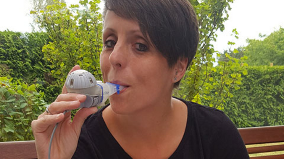 Christine Braune inhaling on her balcony.