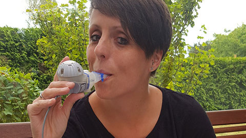 Christine Braune inhaling on her balcony.