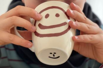 Close-up of a cup held in the hands of a child