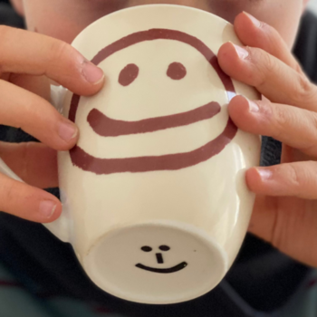 What can be done if a child has mucus in their throat: Drink plenty Close-up of a cup held in the hands of a child