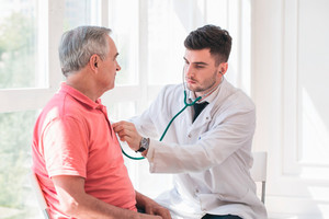 Älterer Mann wird von Arzt mit Stethoskop untersucht