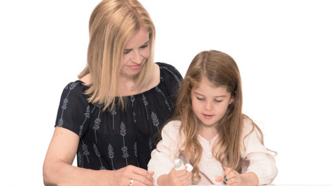 Asthmaanfall bei Kindern: Vorbereitet sein Mutter schaut Tochter zu, die Asthmaspray in der Hand hält und untersucht