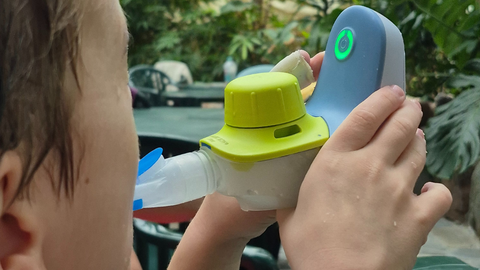 Kind inhaliert mit dem PARI BOY free im Schwimmbad.