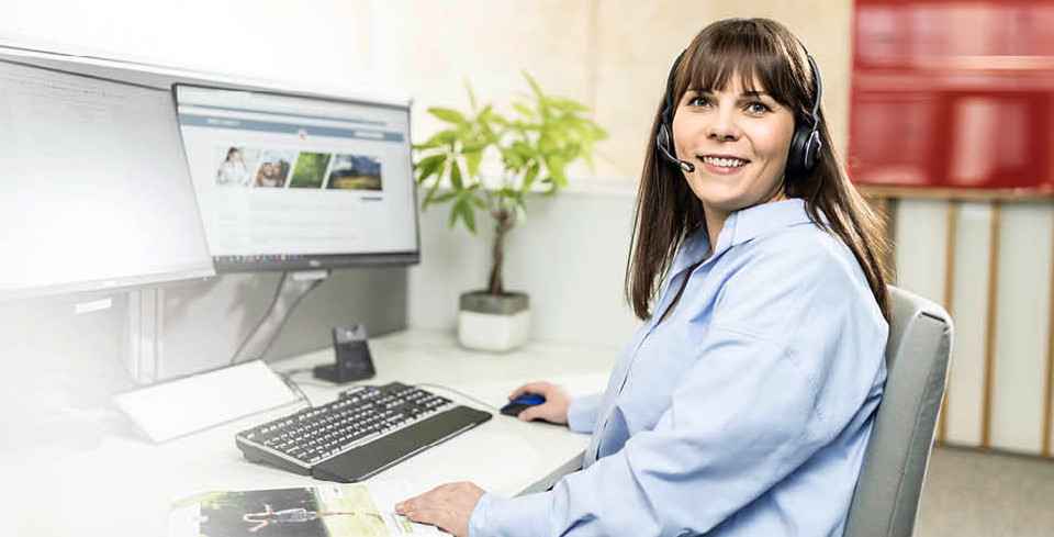 A PARI service employee sits in front of a computer with a headset and advises a customer over the phone