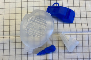 Individual parts of the nasal douche lie on a towel to dry