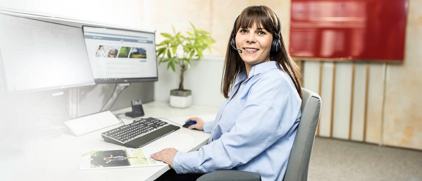 A PARI service employee sits in front of a computer with a headset and advises a customer over the phone