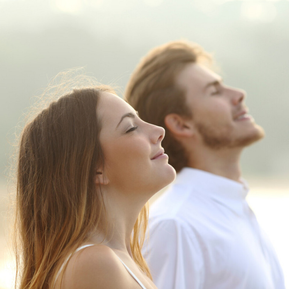 Breathing through your nose: 7 reasons you should always breathe in through your nose Young woman in foreground and young man in background breathing relaxed through nose