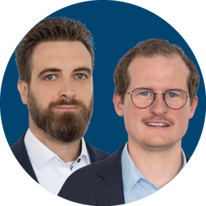 Two smiling men in a blue circle. The central man wears glasses and a light blue shirt. The man on the left has a beard and a blue patterned shirt.