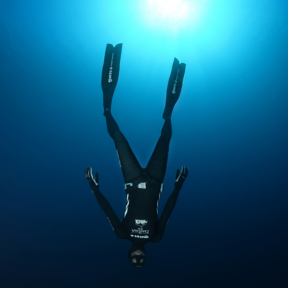 Totale eines Tauchers, der kopfüber im Wasser hängt