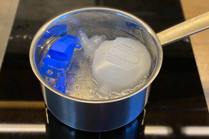 Auseinandergelegte Nasendusche liegt in Topf mit kochendem Wasser