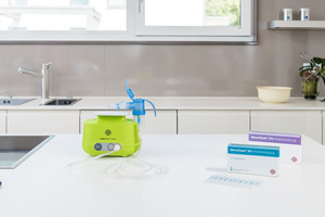 Inhalation device and two packs of inhalation solution are on the kitchen table