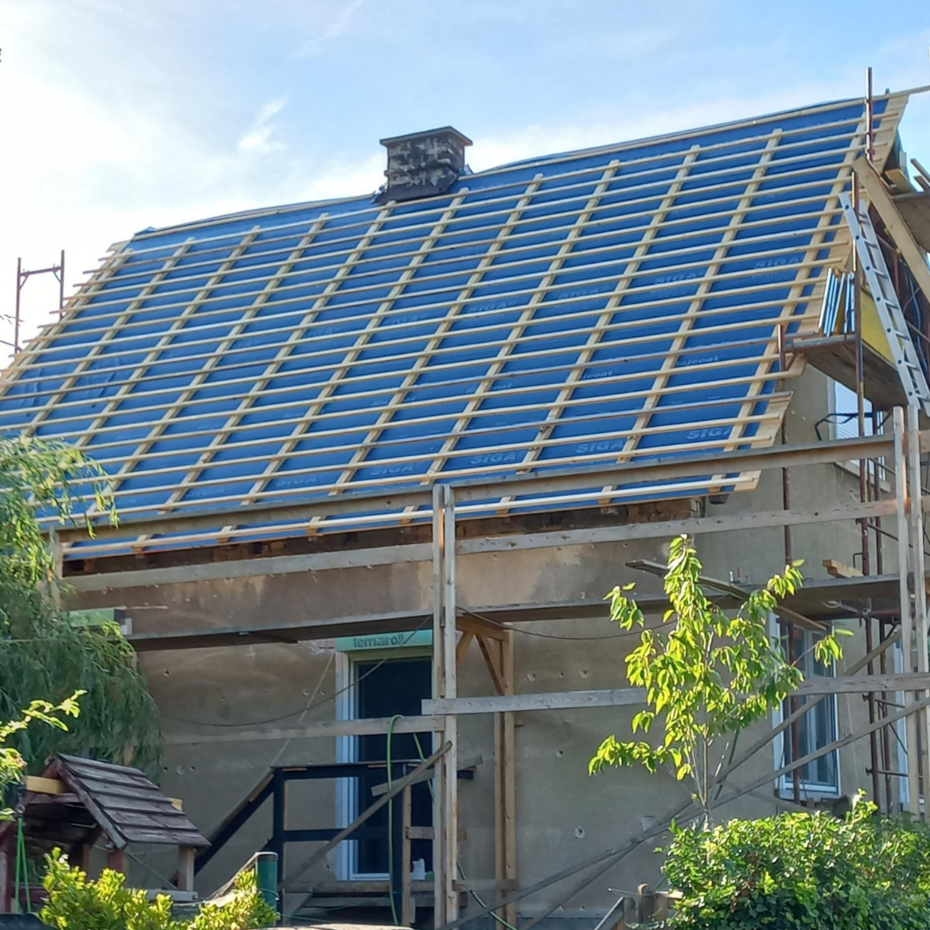 Haus von der Seite mit abgedecktem Dach und Gerüst