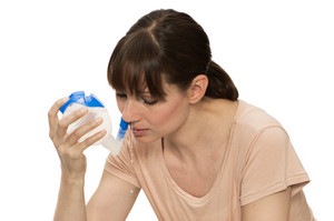 Frau setzt Nasendusche an Nase an