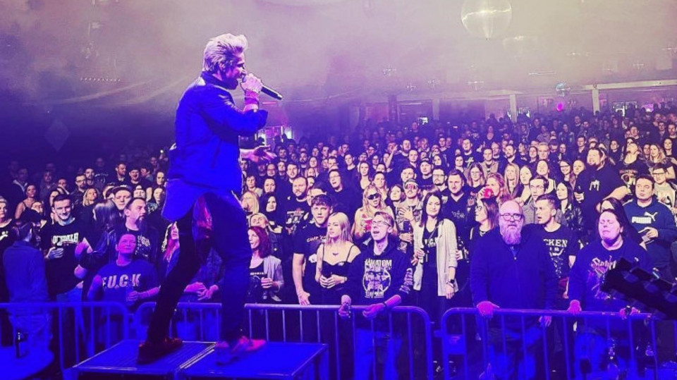 Sänger auf der Bühne vor jubelndem Publikum