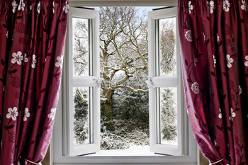 Geöffnetes Fenster mit Blick auf den winterlichen Garten