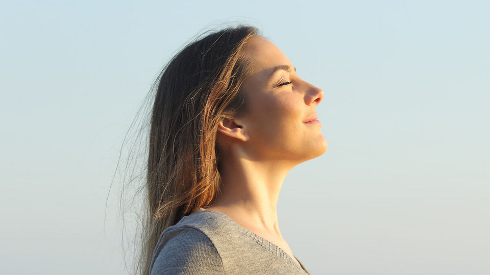 Frau von der Seite, die mit geschlossenen Lippen entspannt atmet