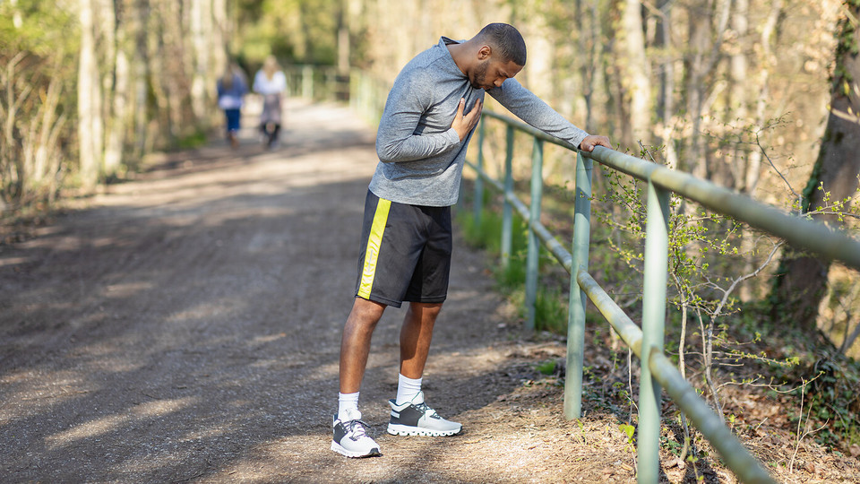 Junger Mann hat Atemprobleme beim Joggen