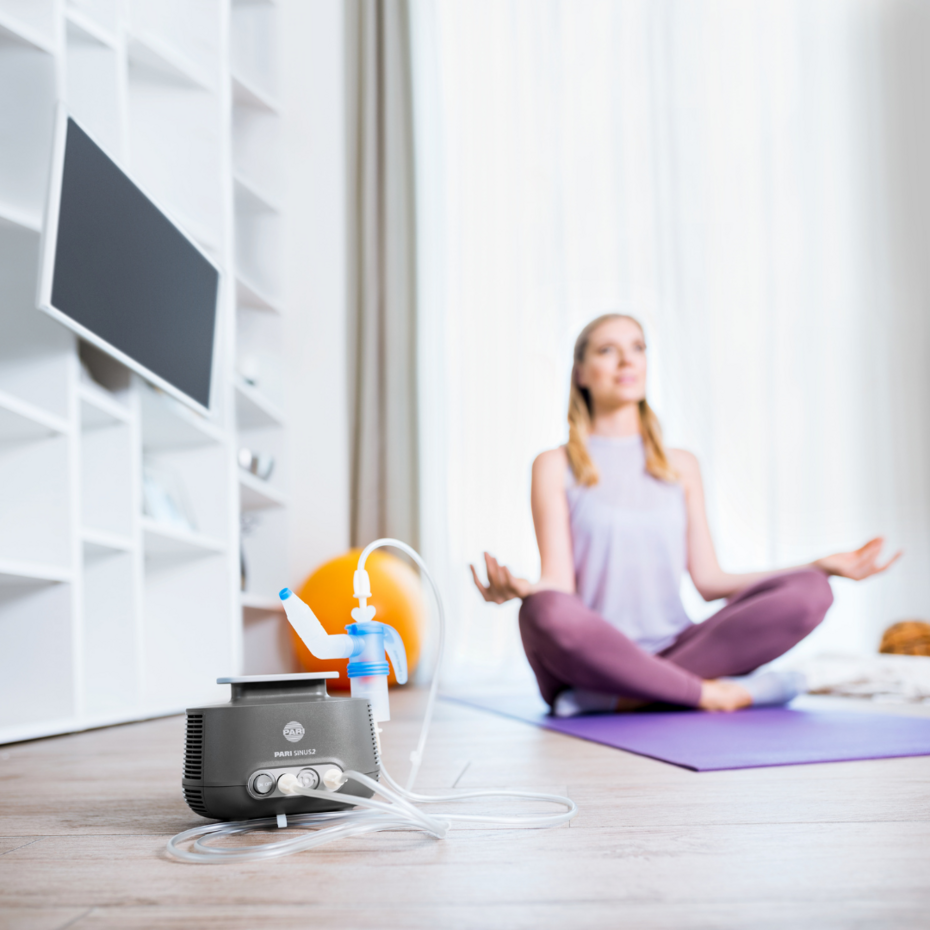 Junge Frau meditiert, im Vordergrund steht der PARI SINUS2