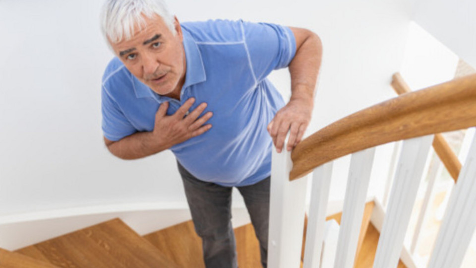 Älterer Mann steht auf Treppe mit Hand auf der Brust