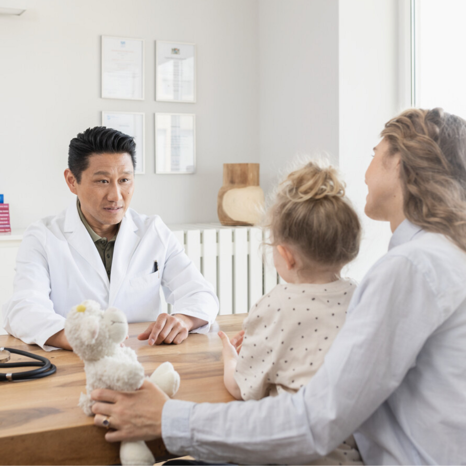 Junge Mutter sitzt mit ihrer Tochter beim Kinderarzt
