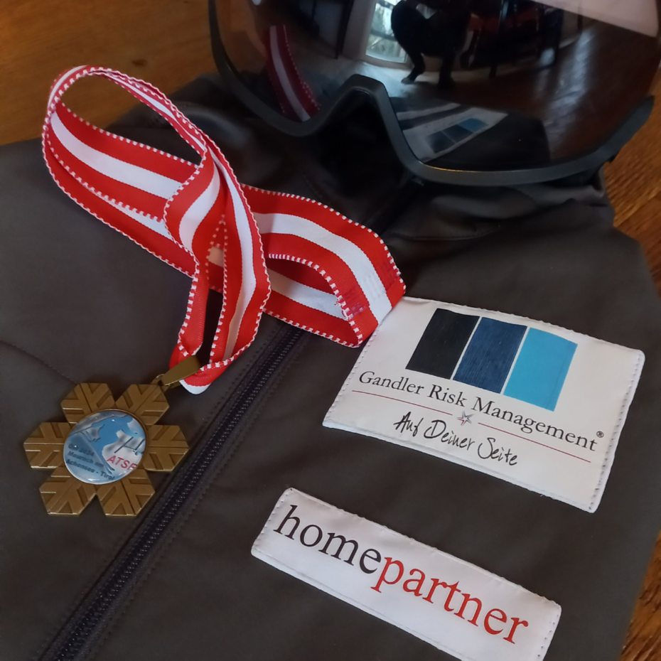 Bernhard Kaut auf dem Endspurt: Skimeisterschaft der ATSF Bronze-Medaille liegt auf Trikot, oben im Bild ist ein Ski-Helm zu sehen