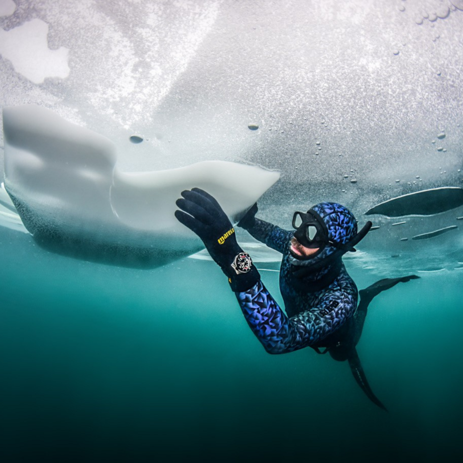 Apnoetaucher taucht unter einer Eisdecke entlang