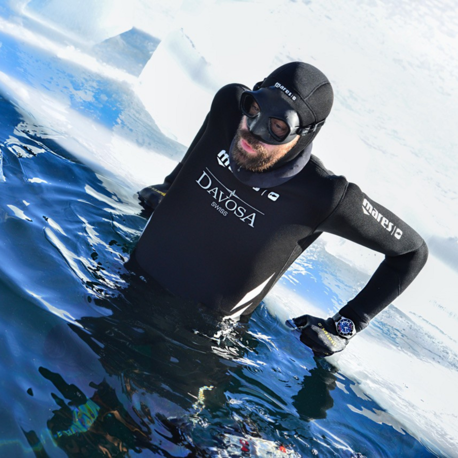 Taucher ist kurz davor, durch ein Loch in der Eisdecke abzutauchen
