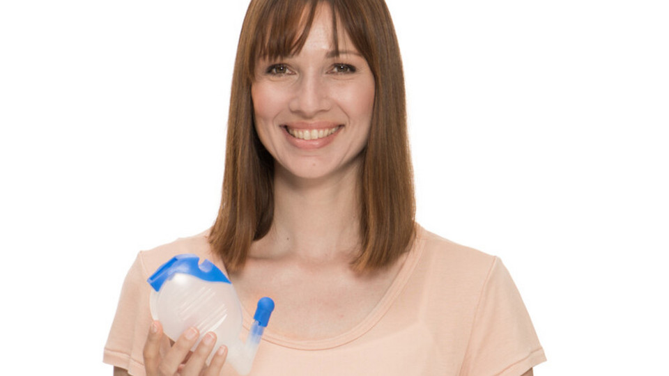 Frau in Halbnahaufnahme hält PARI Montesol Nasendusche in die Kamera