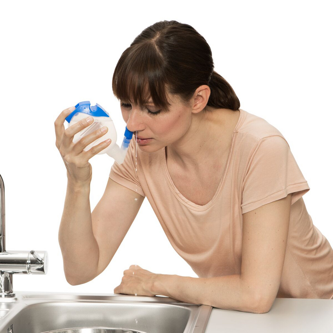 Home remedies against a cough: PARI Montesol nasel douche Young woman bends over the sink and uses the PARI Montesol nasal douche