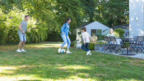 Urlaub mit Asthma: Wozu Lungenärzte raten Familie spielt Fußball im Hotelgarten