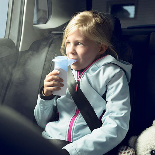 Kind auf dem Rücksitz eines Autos nutzt eine PARI BOY Go Inhaliergerät Kind auf dem Rücksitz eines Autos nutzt eine PARI BOY Go Inhaliergerät; ein Stofftier liegt daneben.