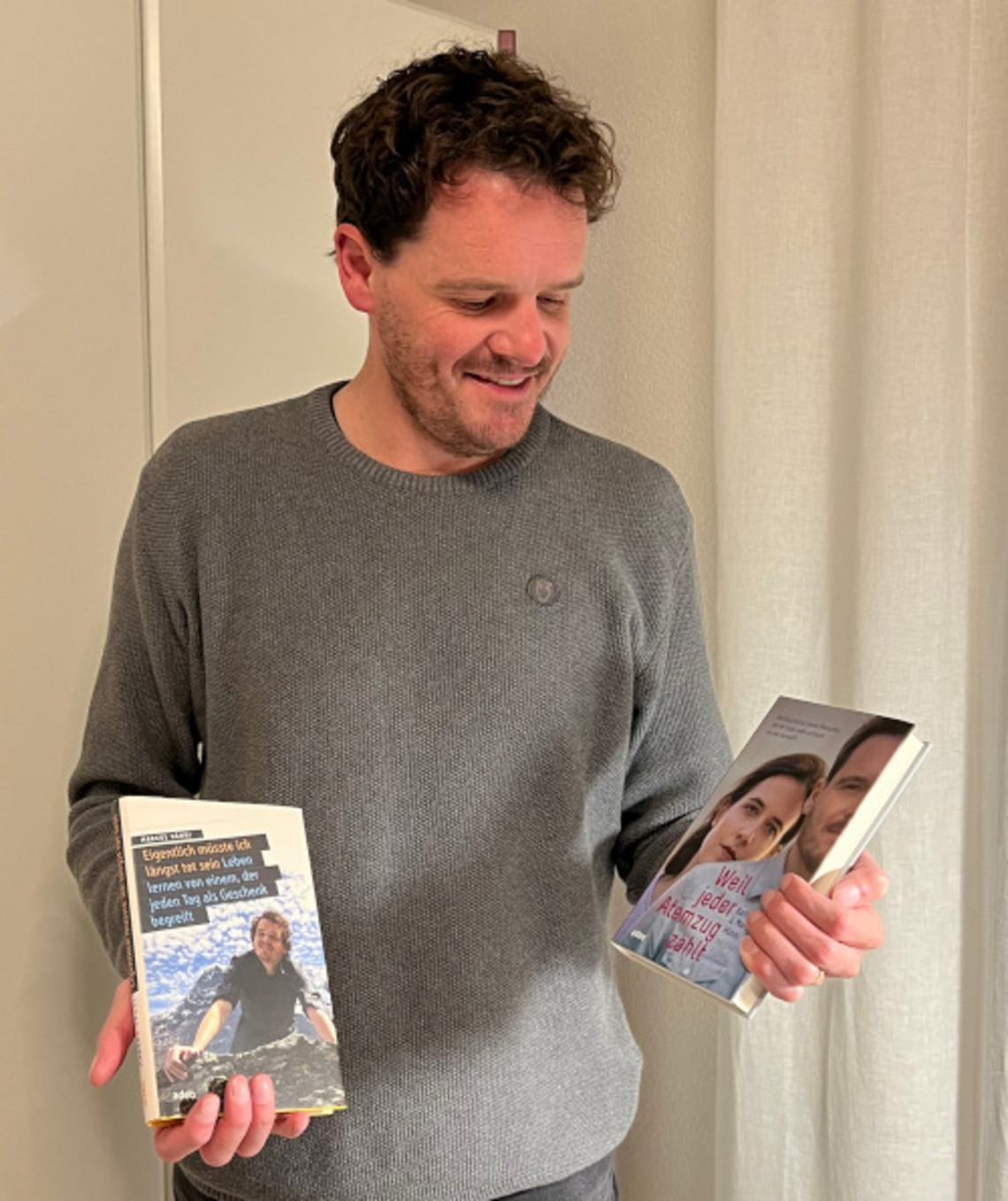 Kinderwunsch: Mit Mukoviszidose Vater werden? Gespräch mit Markus Hänni Stehender Mann mit zwei Büchern in der Hand