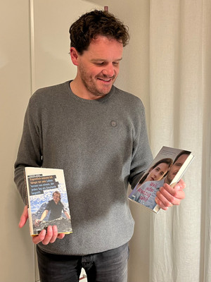 Standing man with two books in his hand