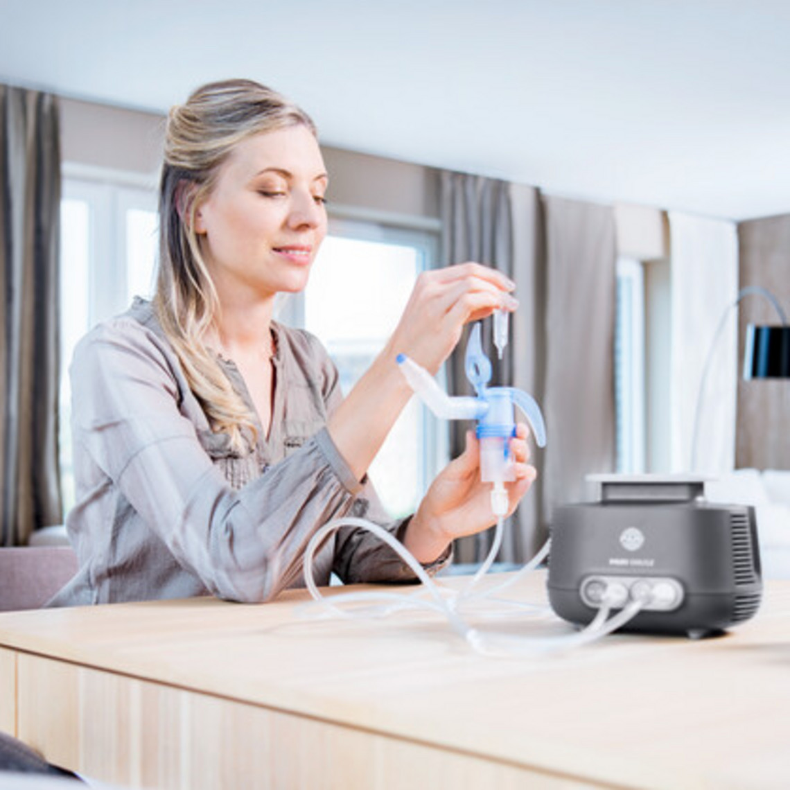 Schnupfen schnell loswerden: PARI SINUS2 Frau füllt am Tisch sitzend Inhalationslösung in den PARI SINUS2