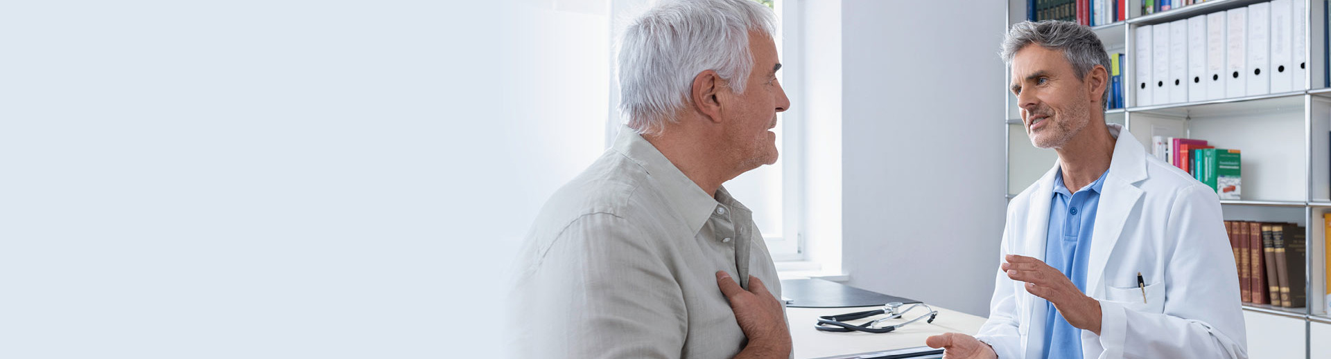 Ein Arzt spricht mit einem älteren Patienten über Inhalationstherapie
