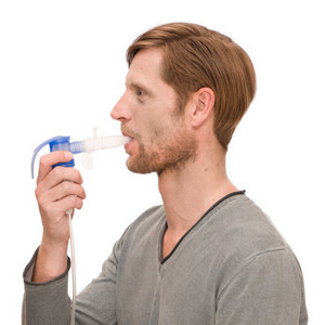 Mann inhaliert mit Vernebler mit aufgestecktem PEP-System