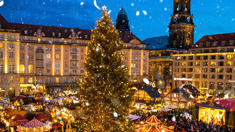 Bild eines von vielen Lichtern beleuchteten Weihnachtsmarktes in einer Stadt