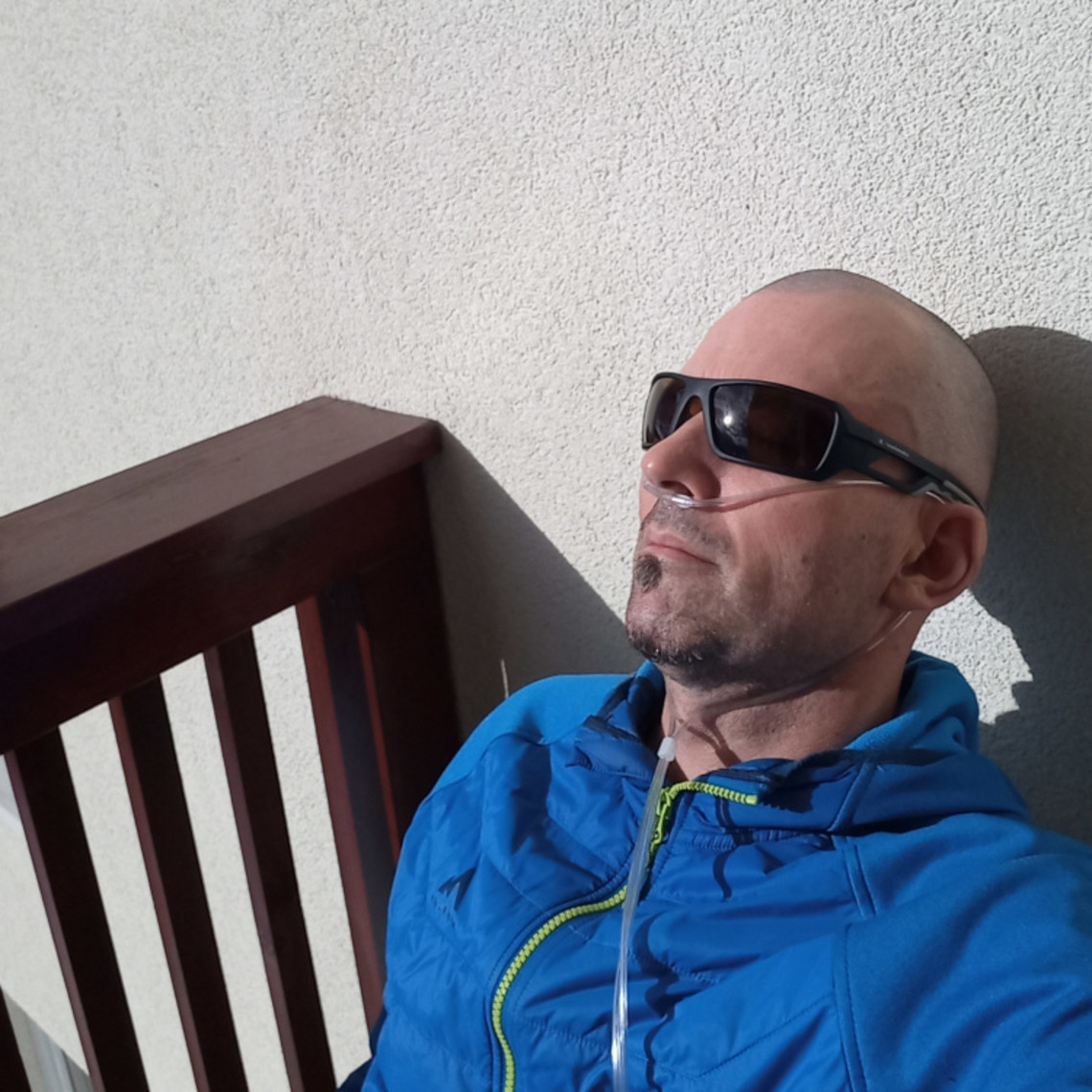 Bernhard Kaut im Interview– Transplantation oder Bestatter: Sauerstoff Mann sitzt mit Sonnenbrille an Hauswand gelehnt da mit Sauerstoffgerät
