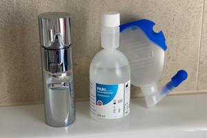 Nasal douche and nasal rinse stand next to water tap on water basin
