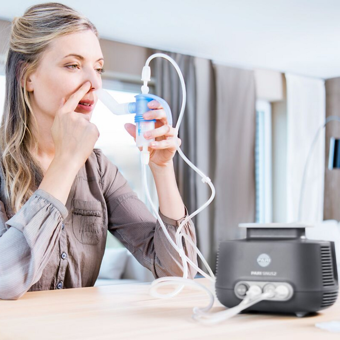 Young woman is inhaling with the PARI SINUS2 nebuliser