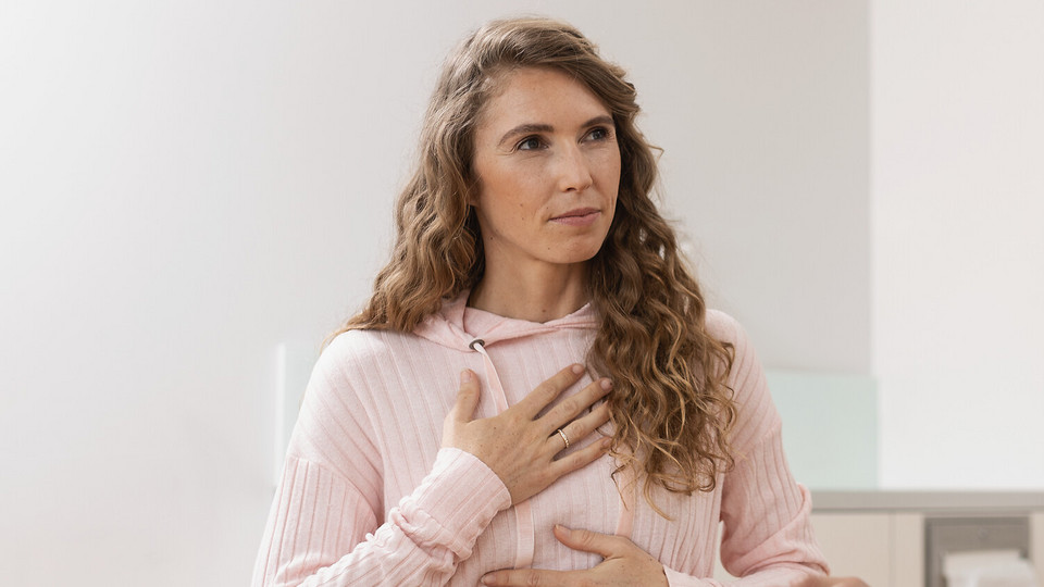 Bronchiektasen-Therapie und Behandlung: Tipps für Betroffene Junge Frau hält sich die Hände an die Brust