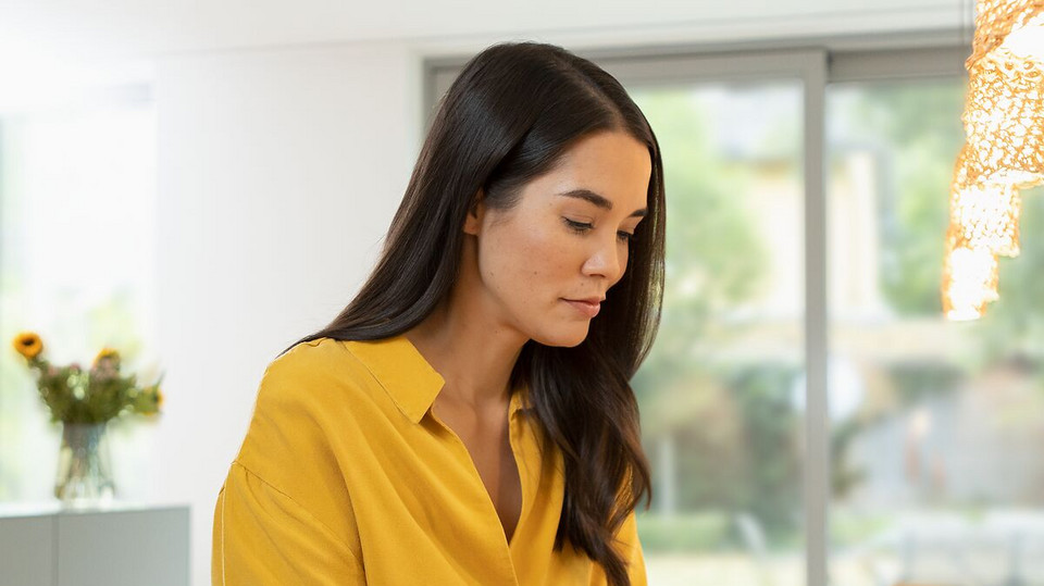 Junge Frau sitzt entspannt da und blickt nach unten