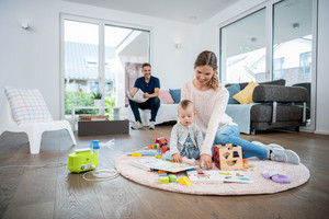 Mother sits on the carpet with toddler and plays