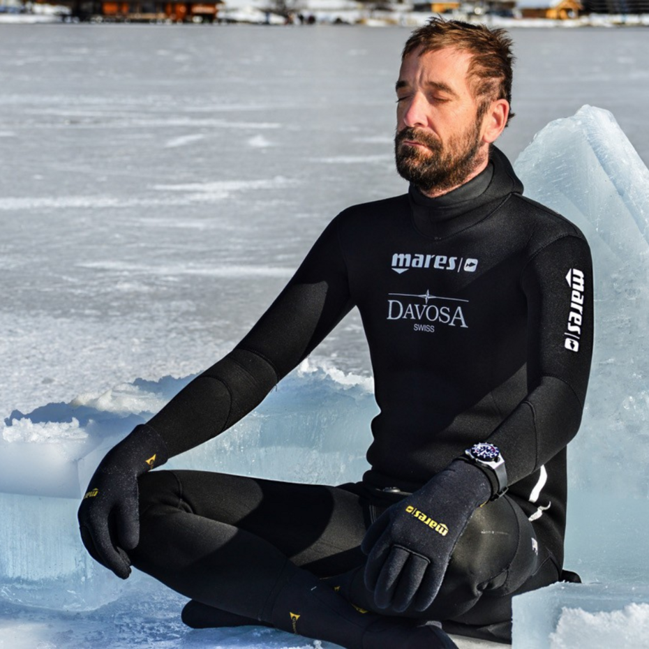 Taucher sitzt auf einer Eisfläche und konzentriert sich