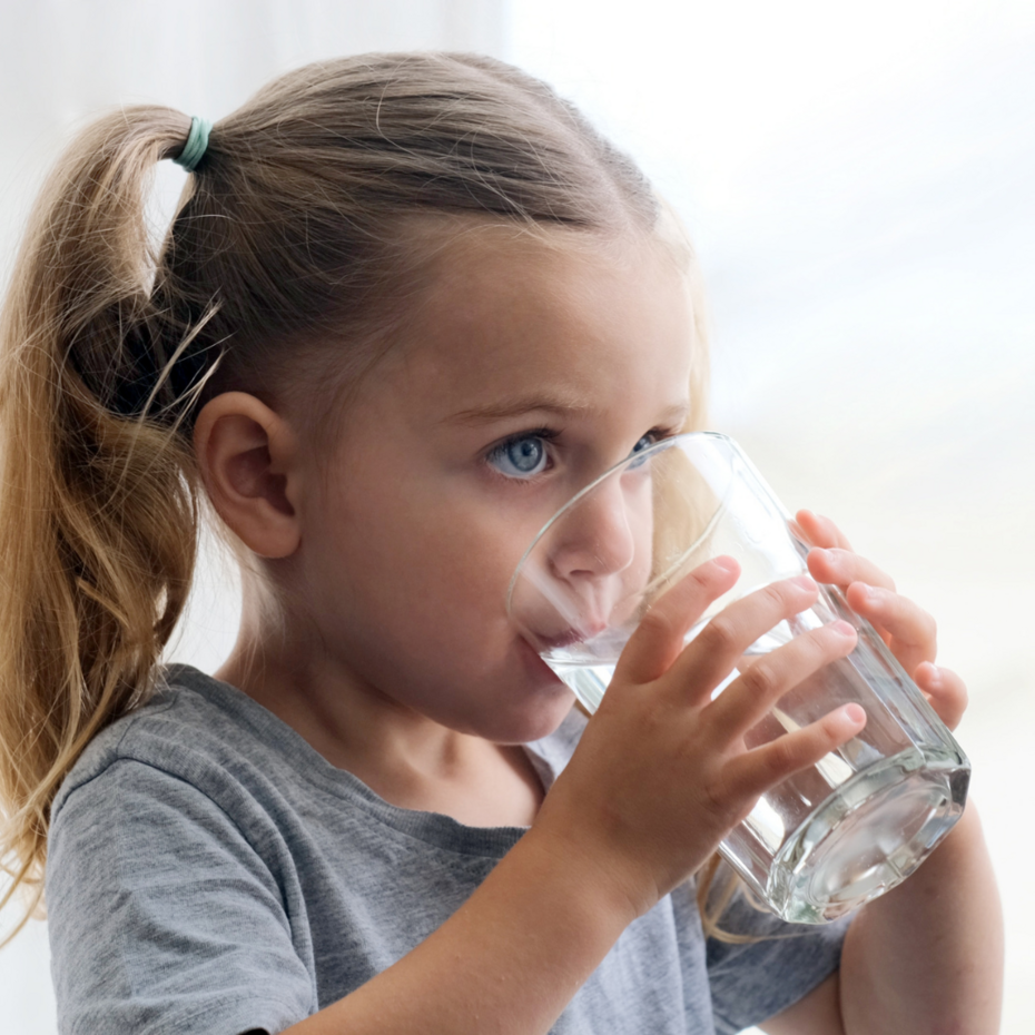 Kleines Mädchen trinkt aus einem Wasserglas