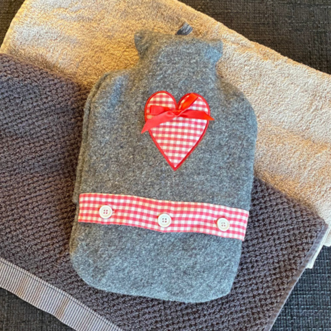 Home remedies against a cough: Moist heat Hot water bottle lies on two towels