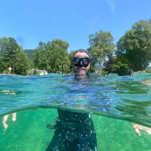 Taucher im Wasser, der Kopf ist über der Wasseroberfläche