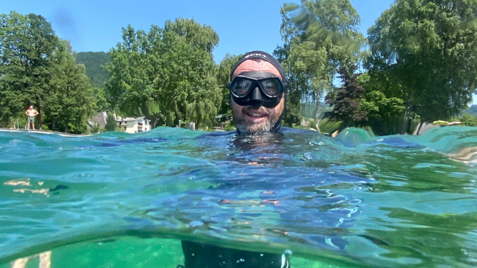 Taucher im Wasser, der Kopf ist über der Wasseroberfläche